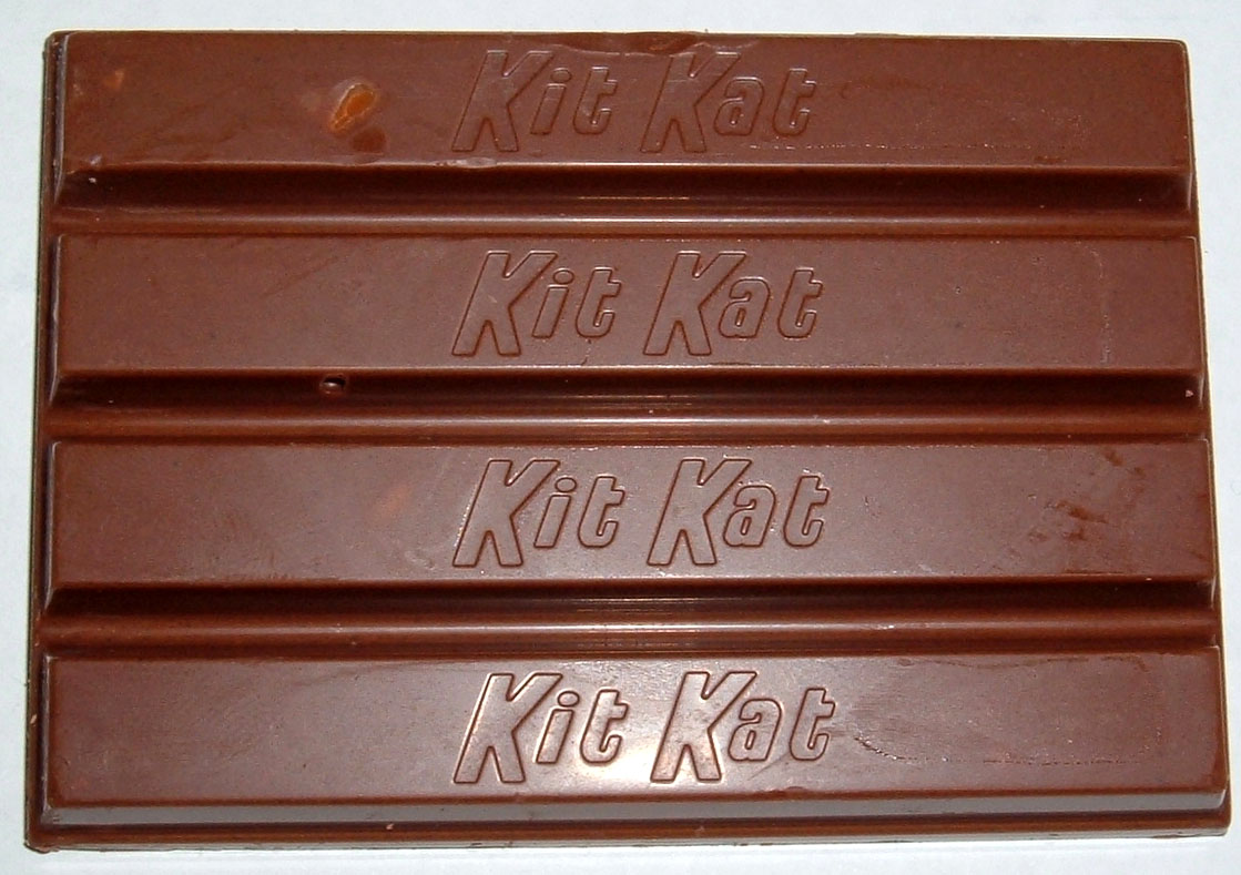 Four fingers of a Kit Kat chocolate bar, each embossed with Kit Kat without a hyphen.