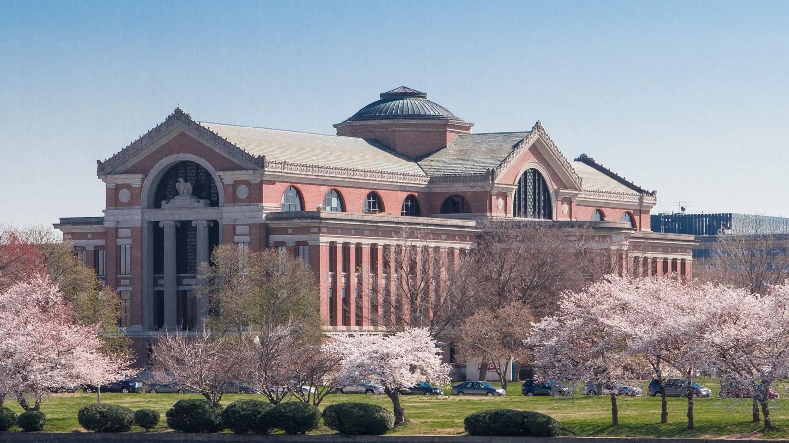 Roosevelt Hall at the National War College in Washington, DC, with its domed roof, red-brick facades, and flowering cherry trees.